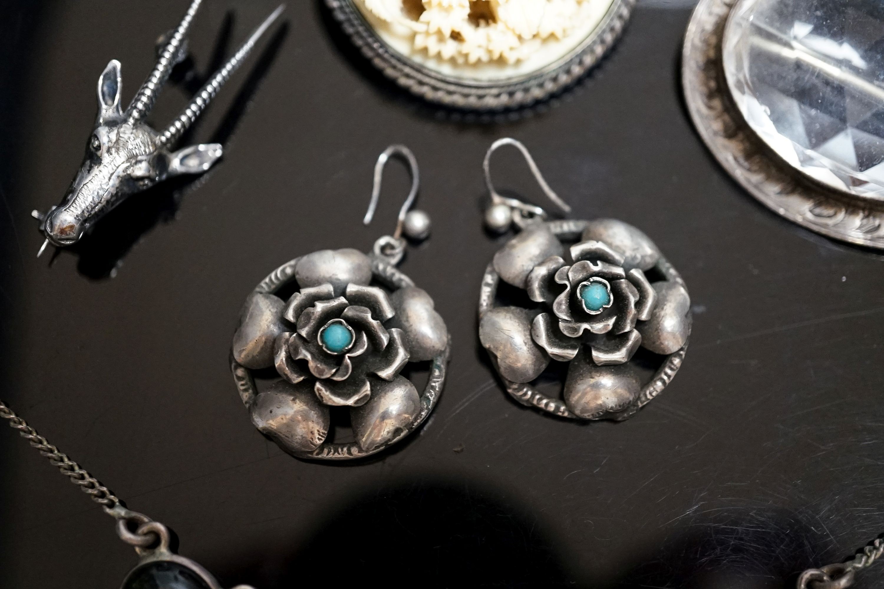 A pair of white metal and turquoise set earrings, a gem set necklace, deer head brooch and two oval brooches.